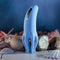 Selopa Tentacle Tickler silicone clitoral stimulator in blue, featuring six floppy tentacles and a sleek design on a rocky surface.