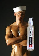 Swiss Navy Silicone Lubricant 2 Oz displayed next to a muscular model in a sailor outfit.