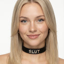 Strict Leather ID Collar Slut in Black worn by a model, featuring bold lettering and black leather.