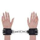 Sportsheets Signature Midnight Muse Handcuffs on hands with silver hardware for sophisticated restraint play.