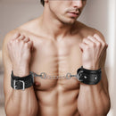 Close-up of Strict Leather Deluxe Locking Wrist Cuffs with a metal chain, secured on bare wrists, showcasing their strong design.