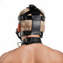 Strict Leather Padded Muzzle Black worn by a model, showcasing the intricate leather straps and padding.