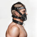 Strict Leather Padded Muzzle Black on a model, showcasing its design and secure fit for bondage play.