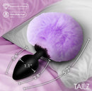 Tailz Fluffy Bunny Tail Silicone Plug Purple on a pillow, featuring a fluffy purple tail and smooth silicone design.