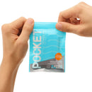 Hands holding a Pocket Tenga Wave Line Masturbation Sleeve packaging, showcasing its sleek design and travel-friendly format.