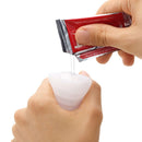 Person pouring lubricant into Pocket Tenga Wave Line Masturbation Sleeve for enhanced pleasure.