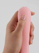 Hand holding Tenga Iroha Mai Toki personal massager in soft pink color.