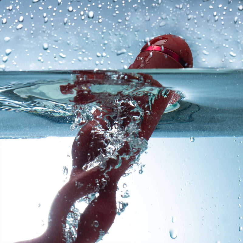 UEROS Multi-motor Pulse Vibrator Red submerged in water, showcasing its unique design and waterproof feature.