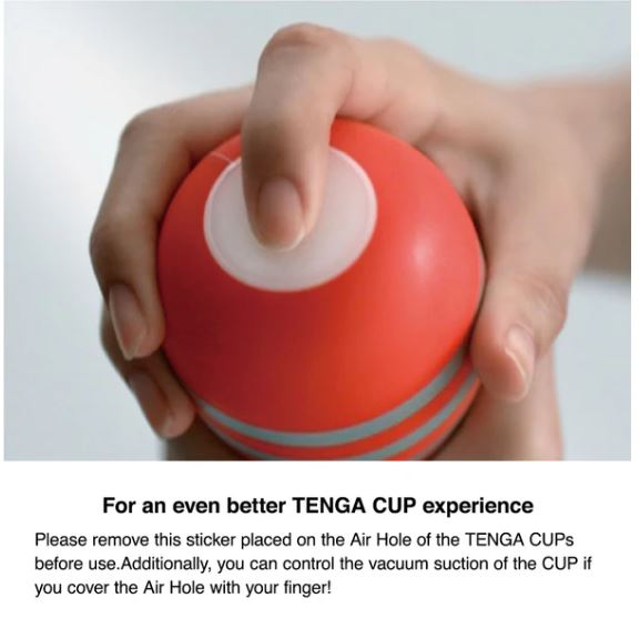 Hand holding Tenga Original Vacuum Cup Strong with sticker instructions for better suction experience.