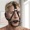 Strict Leather Ball Gag Harness Black featuring a model wearing a restrictive black leather gag harness.