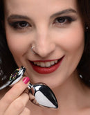 Booty Sparks Prism Heart Anal Plug Medium held by a smiling woman, showcasing its radiant design and heart-shaped gem.