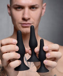 Master Series Triple Spire Tapered Silicone Anal Trainers 3 Pc Set held by a model showcasing the three different sizes.