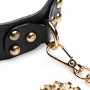 Close-up of the Master Series Black & Gold Bondage Set collar with studs and gold chain attachment.