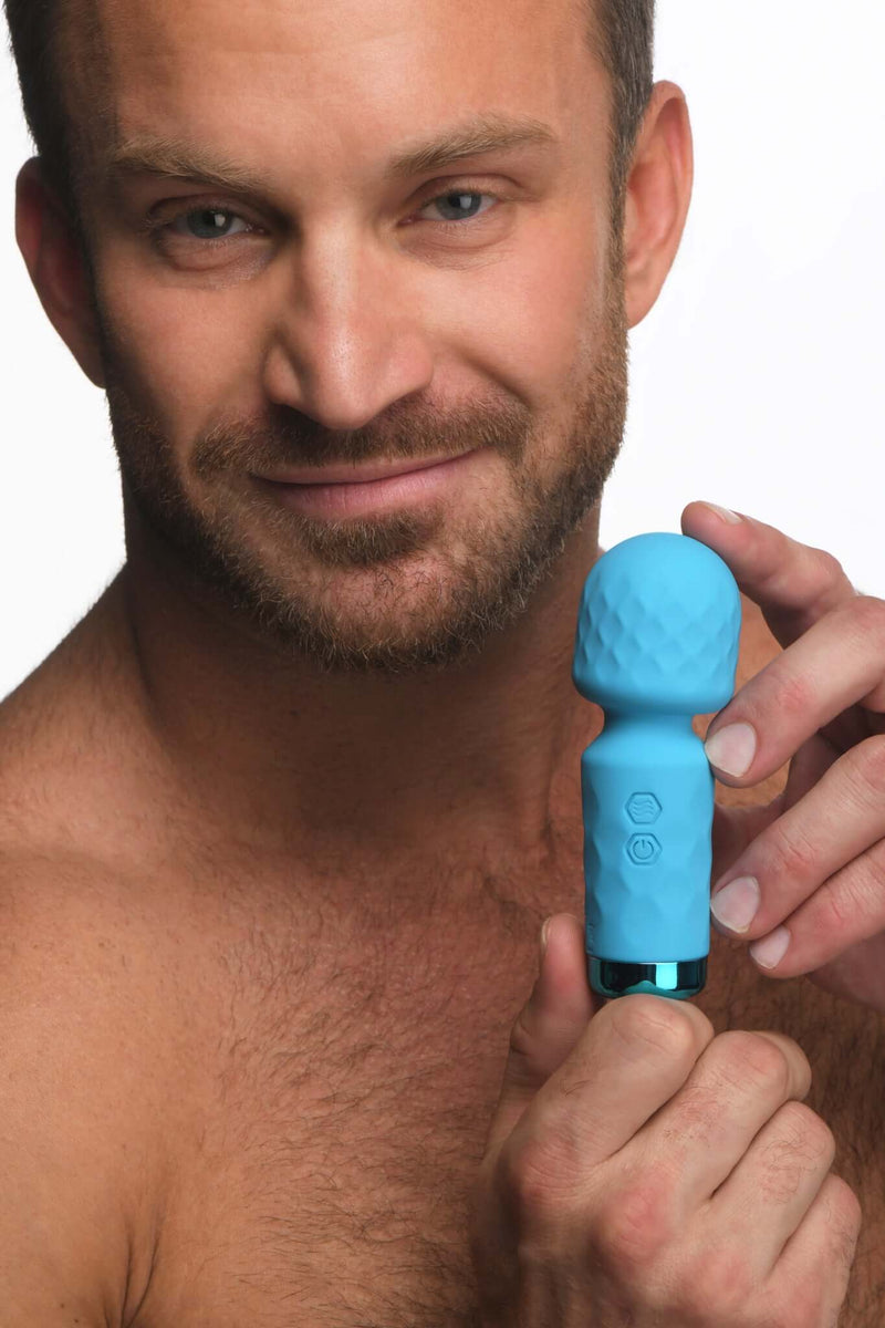 Man holding the Bang! 10X Mini Silicone Rechargeable Wand in blue, showcasing its design for discreet pleasure.