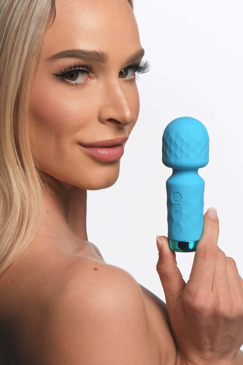 Bang! 10X Mini Silicone Rechargeable Wand in blue held by a model, showcasing its sleek design for discreet pleasure.
