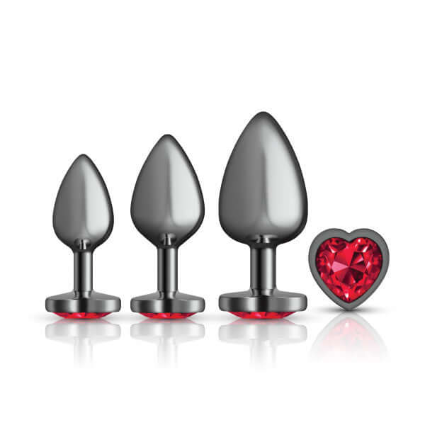 Cheeky Charms Metal Butt Plug Set in gunmetal with red heart gemstones, sizes small, medium, and large, included in anal trainer kit