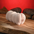 Zero Tolerance Riley Reid Mini Stroker Vagina on a wooden surface with rocks in the background, highlighting its lifelike design.