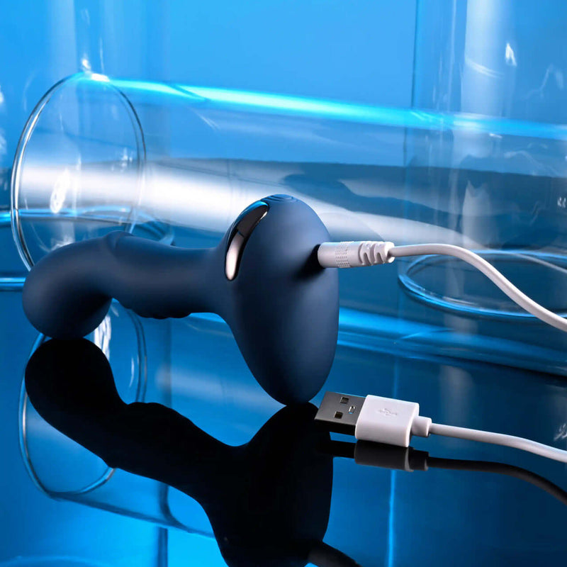 Zero Tolerance Blue Oasis silicone plug charging with USB cable against a blue background