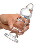 A hand holding the Prisms Param Glass Anal Plug Clear, showcasing its elegant design and clear glass material.