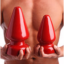 Master Series Anal Destructor Small Butt Plug Red held by a person showcasing its design and color.