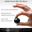Master Series Jaded Glass Ben Wa Balls Green held in hand, showcasing sleek design and ideal for Kegel exercises.