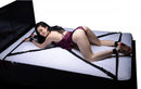 Master Series Interlace Bed Restraint Set on a bed with a smiling user in an adjustable position.