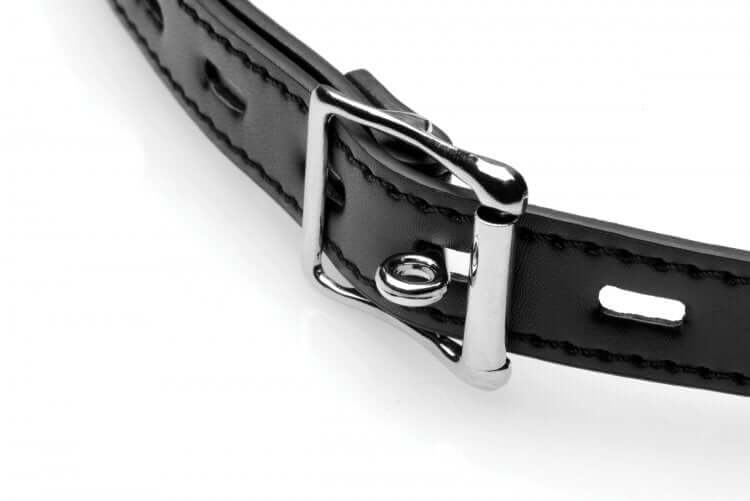 Close-up of a black leather collar with a shiny silver buckle, ideal for BDSM play and bondage.