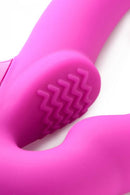 Close-up of the Strap U Evoke rechargeable pink silicone strapless strap-on with textured surface.