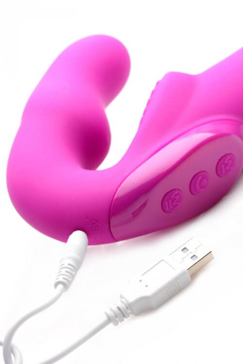 Pink rechargeable silicone vibrating strapless strap on with USB charging cable and control buttons.