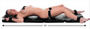 STRICT XL Padded Folding Bondage Board Black with a person secured, showcasing D-ring attachment points and cushioned design.