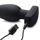 The Taper 10X Silicone Remote Control Vibrating Butt Plug with USB charging cable connected.
