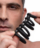 Strict 6 Ring Silicone Chastity Device Black held by a man, showcasing its flexible design for chastity play.