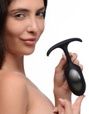 Model holds Heavy Hitters Premium Silicone Weighted Anal Plug Large, showcasing its sleek design and comfort features.