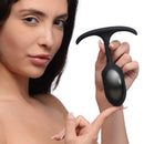 Woman holding Heavy Hitters Premium Silicone Weighted Anal Plug Medium, showcasing its sleek design and comfort for extended wear.