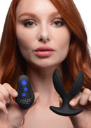 64X Electro-Spread Vibrating and Estim Silicone Butt Plug shown with remote control in model's hands.