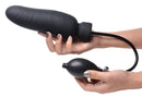 Master Series Dick-Spand Inflatable Silicone Dildo Black with hand bulb in a woman's hands.
