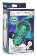 Booty Sparks Glow-In-The-Dark Glass Anal Plug Large packaging featuring luminous green design and glowing text.