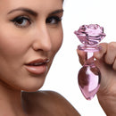 Booty Sparks Pink Rose Glass Anal Plug Large held by a model, showcasing its elegant glass rose design.