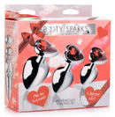 Booty Sparks Red Heart Gem Anal Plug Set featuring three graduated metal plugs with ruby-red heart-shaped gems.