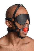 Strict Blindfold Harness and Red Ball Gag displayed on a model, featuring a leather-like blindfold and red ball gag.