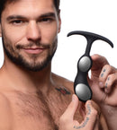 Heavy Hitters Silicone Weighted Prostate Plug Medium Black held by a man, showcasing its two-bulb design.