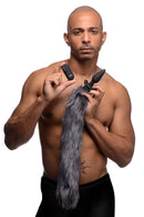 Vibrating Silicone Anal Plug with 3 Interchangeable Tails in a model's hand with remote and gray fox tail.