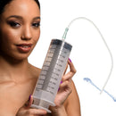 CleanStream Enema Syringe with Tube 550ml Clear held by a model, showcasing measurement markings and tapered tip.