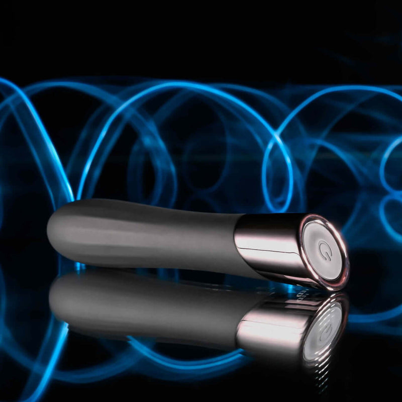 Evolved Back in Black Petite Vibrator with chrome tip and textured shaft on reflective surface, featuring blue light trails in the background.