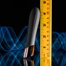 Evolved Back in Black Petite Vibrator beside a yellow ruler against a blue wavy background, showcasing size and sleek design.