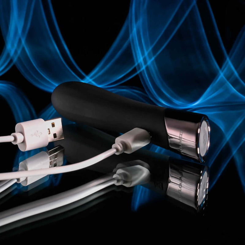Evolved Back in Black Petite Vibrator with USB cable, featuring sleek black design, chrome tip, and easy-grip handle on reflective surface.