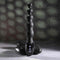 Flexible beaded vibrator with 9 speeds for intense backdoor play by ZERO TOLERANCE, displayed on smooth stones.