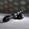 Black flexible beaded vibrator with digital controls on stone background designed for intense backdoor play