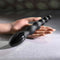 Flexible beaded vibrator with 9 speeds for intense backdoor play held in hand on a concrete surface