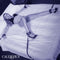 Woman restrained with Nocturnal™ Collection Bed Restraints, displaying versatile and durable adjustable cuffs and tethers on bed.